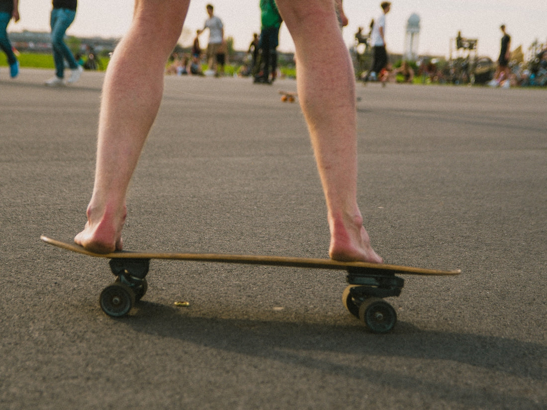 person riding black skateboard on gray asphalt road during daytime