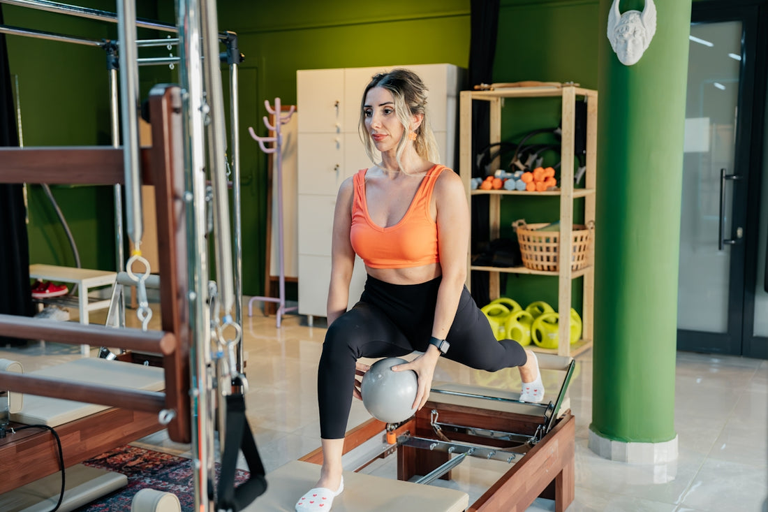 Woman does a lunge with a ball in pilates class.