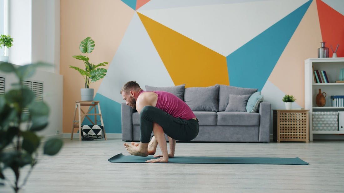 Man practicing yoga crow pose on mat